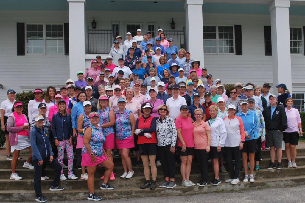 Ladies golf association group photo. All members are dressed in golf attire and standing on the stairs.